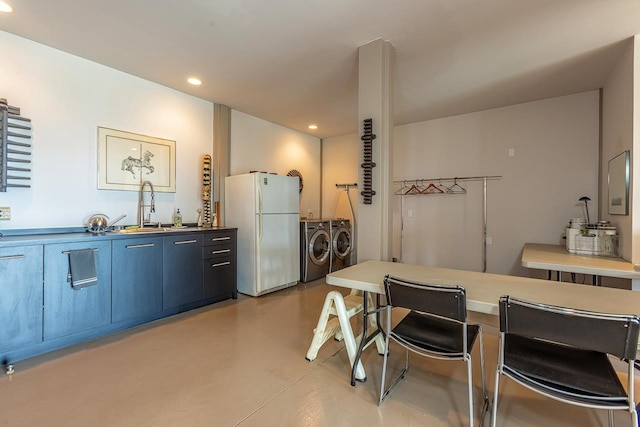 kitchen featuring separate washer and dryer, sink, and white fridge