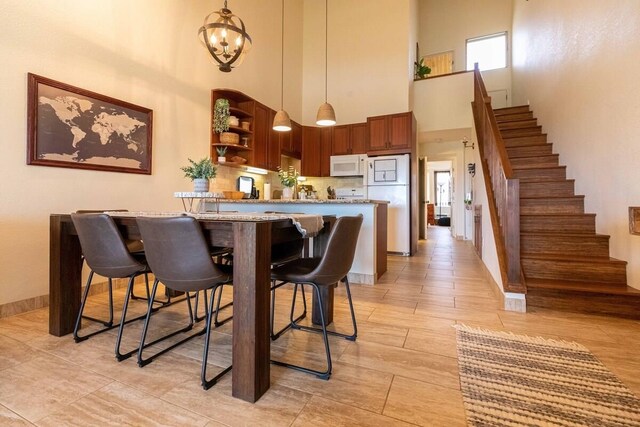 2737 S Kihei Rd Unit 311, Kihei, HI 96753 - kitchen featuring white microwave, a high ceiling, open shelves, freestanding refrigerator, and a kitchen bar