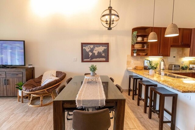 2737 S Kihei Rd Unit 311, Kihei, HI 96753 - dining room with light wood-style floors, a chandelier, and a high ceiling