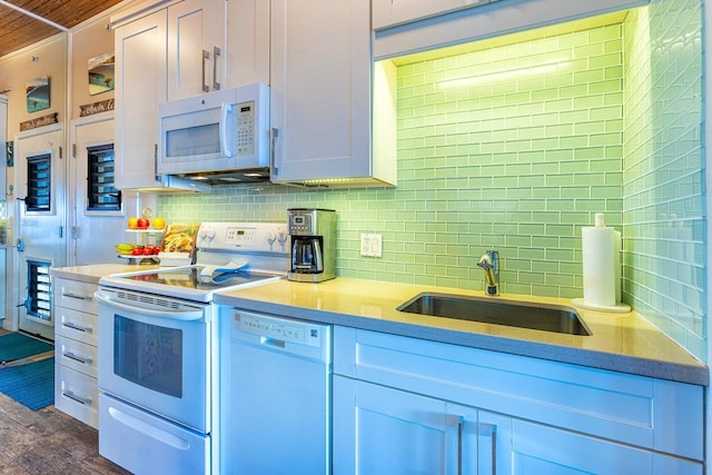 kitchen featuring sink, white cabinets, dark hardwood / wood-style flooring, decorative backsplash, and white appliances