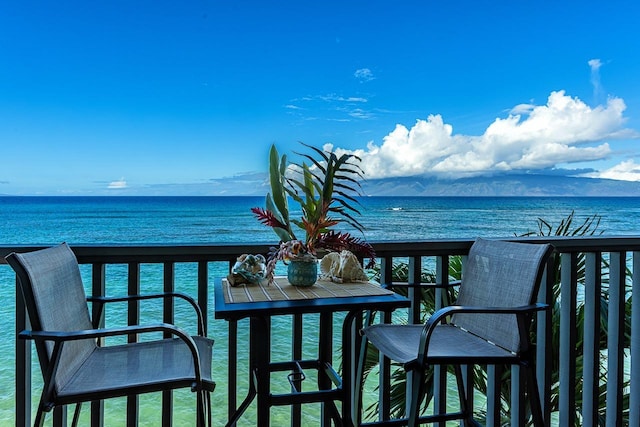 balcony featuring a water and mountain view