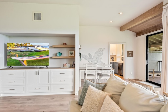 living room featuring sink, vaulted ceiling with beams, and light hardwood / wood-style flooring