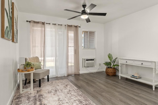 sitting room with plenty of natural light, a wall mounted AC, wood finished floors, and a ceiling fan