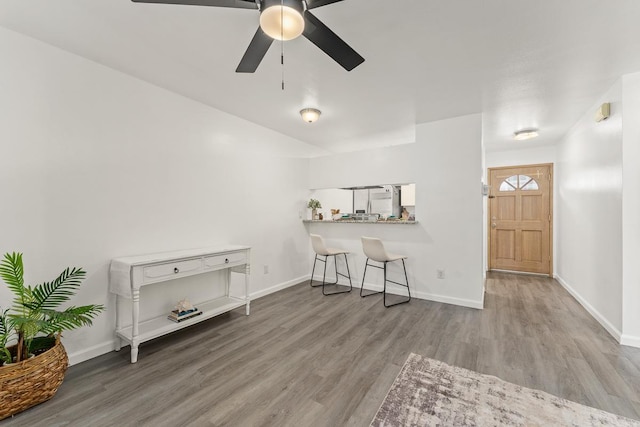 living area featuring wood finished floors, ceiling fan, and baseboards