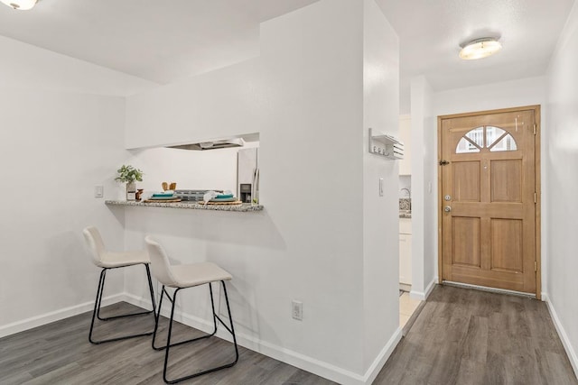 foyer entrance featuring wood finished floors and baseboards