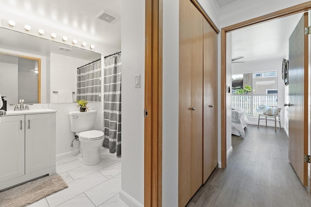 bathroom with toilet, ensuite bath, vanity, and a shower with shower curtain
