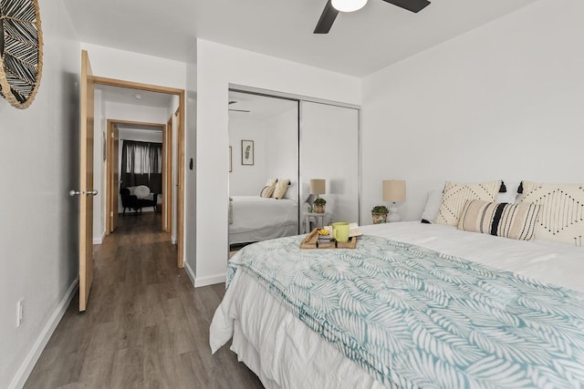 bedroom featuring dark wood finished floors, a closet, baseboards, and ceiling fan