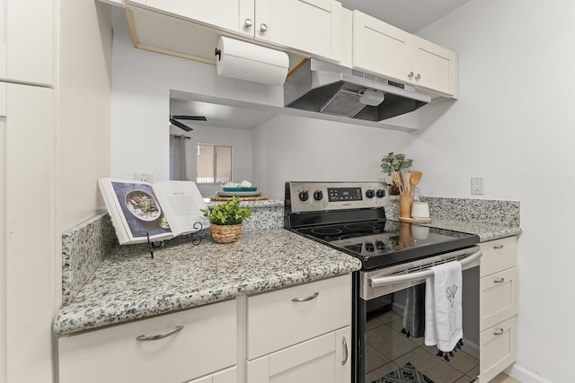 kitchen with stainless steel range with electric stovetop, under cabinet range hood, white cabinetry, and light stone countertops