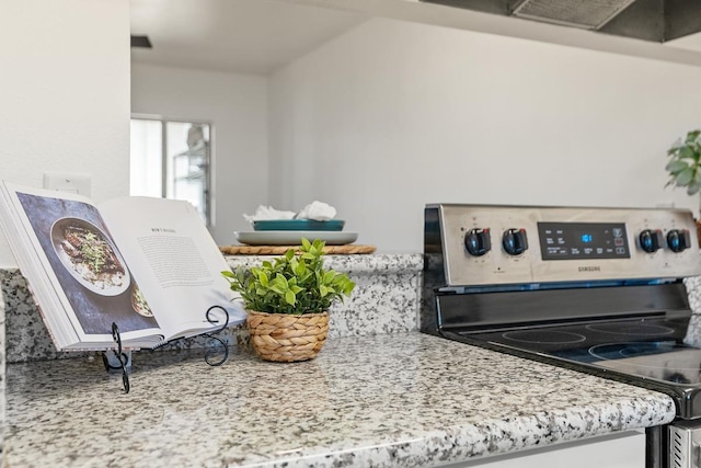 kitchen view of stainless steel electric stove and light stone counters