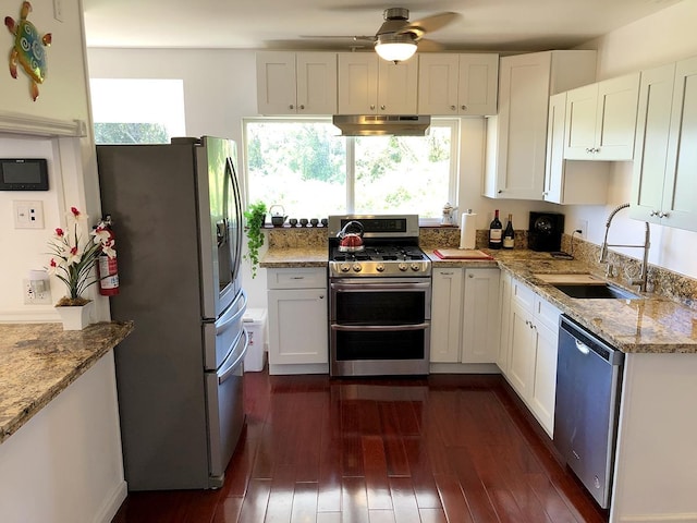 kitchen with sink, light stone countertops, white cabinets, and appliances with stainless steel finishes