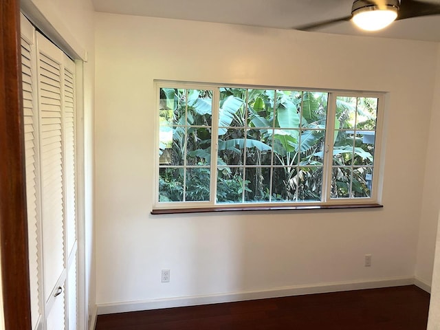 unfurnished bedroom featuring dark hardwood / wood-style flooring, a closet, and ceiling fan