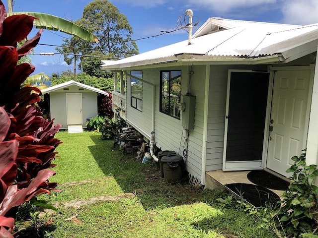 view of home's exterior with a shed and a yard