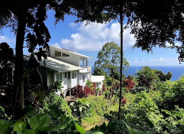 view of side of home with a water view and a balcony