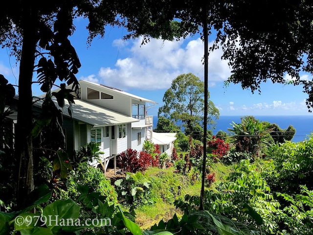 view of property exterior featuring a water view and a balcony