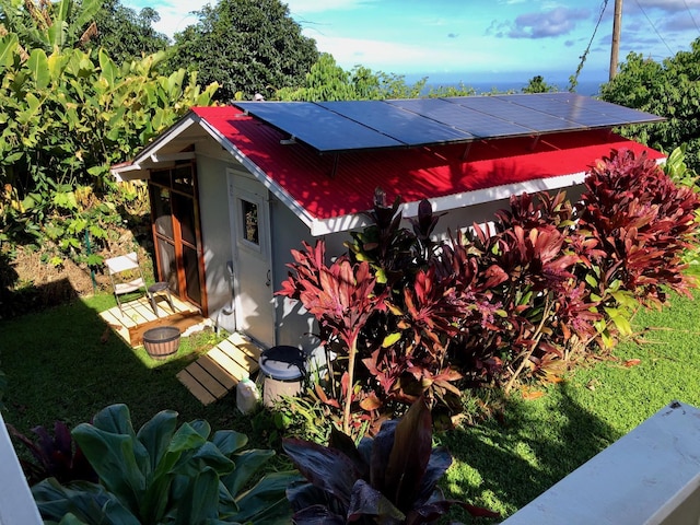 exterior space featuring a lawn and solar panels