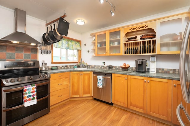 kitchen featuring dark countertops, glass insert cabinets, island exhaust hood, stainless steel appliances, and light wood-type flooring