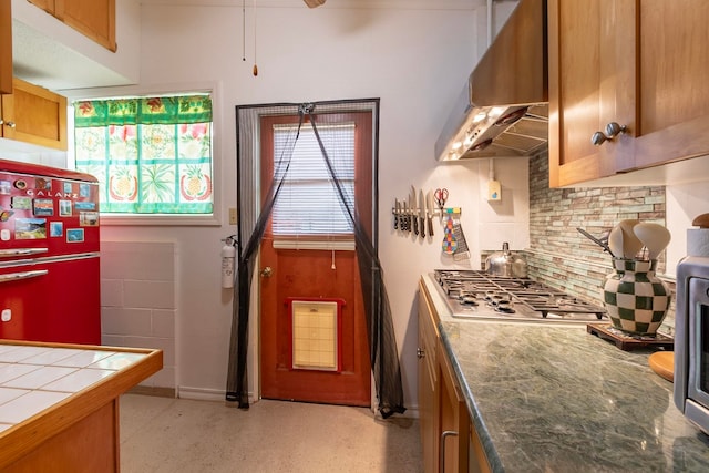 kitchen featuring refrigerator, exhaust hood, and brown cabinets