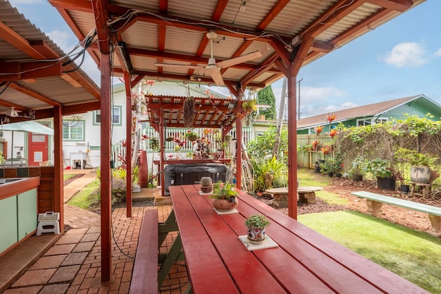 view of patio / terrace featuring a hot tub and fence