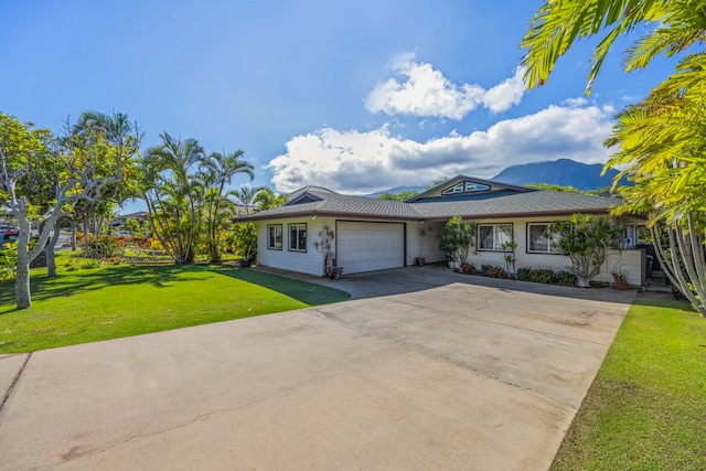 ranch-style home with a mountain view, a front yard, and a garage