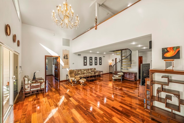 living room with an inviting chandelier, hardwood / wood-style flooring, and high vaulted ceiling