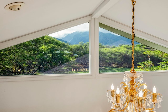 interior details featuring beam ceiling, a mountain view, and an inviting chandelier