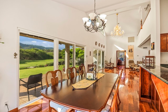 dining room featuring a high ceiling, hardwood / wood-style flooring, french doors, and a notable chandelier