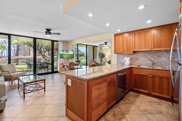 kitchen with kitchen peninsula, decorative backsplash, ceiling fan, and light stone counters