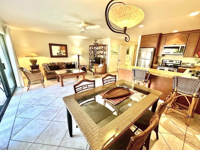 tiled dining space featuring ceiling fan