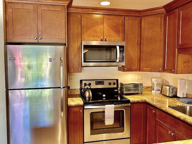 kitchen with stainless steel appliances and light stone counters