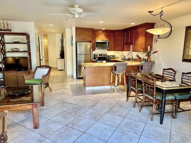 kitchen featuring sink, hanging light fixtures, ceiling fan, kitchen peninsula, and stainless steel appliances