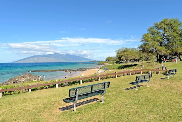 view of property's community with a lawn and a water and mountain view