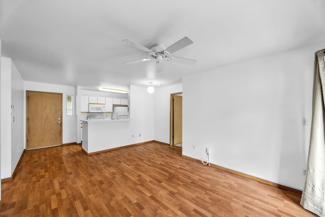 36 Kunihi Ln Unit 213, Kahului, HI 96732 - unfurnished living room featuring wood finished floors, ceiling fan, and baseboards