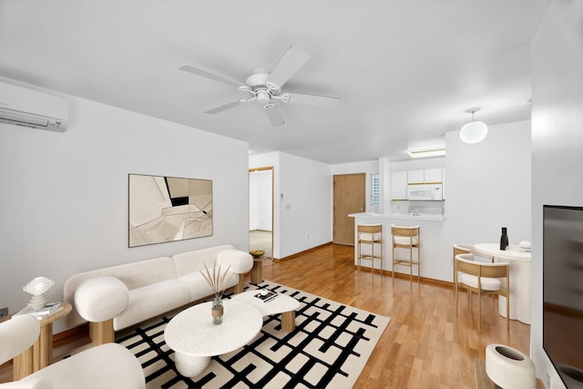 36 Kunihi Ln Unit 213, Kahului, HI 96732 - living room with a ceiling fan, a wall unit AC, light wood-style flooring, and baseboards