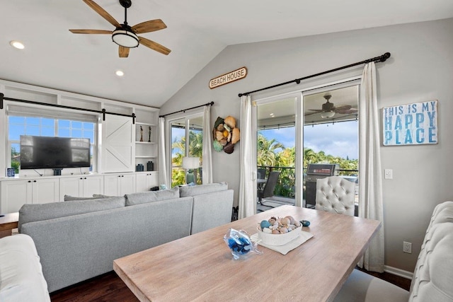 dining space with vaulted ceiling, ceiling fan, a barn door, and a healthy amount of sunlight