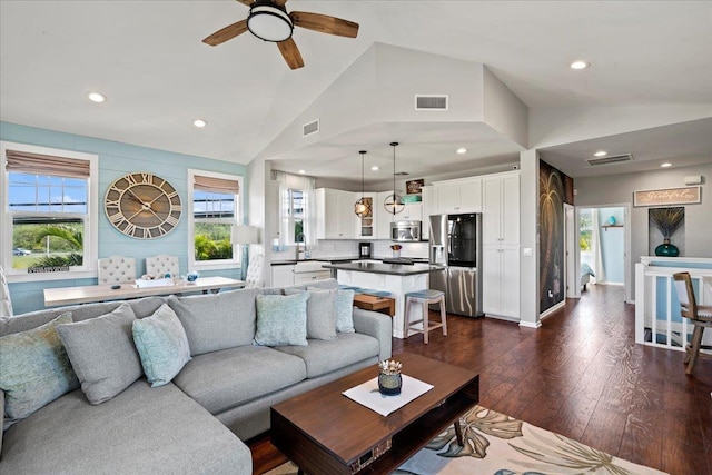 living area featuring dark wood-style floors, lofted ceiling, visible vents, and recessed lighting