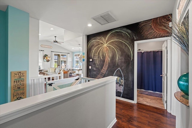 hallway with lofted ceiling, recessed lighting, dark wood-style flooring, visible vents, and an upstairs landing