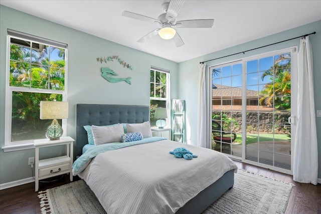 bedroom with access to exterior, multiple windows, and dark wood-style floors