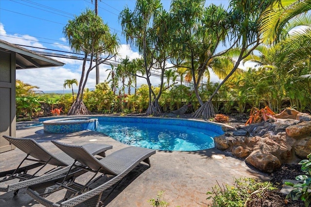 view of swimming pool featuring a pool with connected hot tub and a patio area