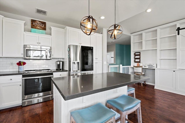 kitchen featuring appliances with stainless steel finishes, dark countertops, and white cabinets