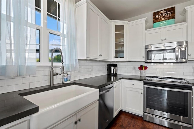 kitchen featuring dark countertops, white cabinetry, and stainless steel appliances