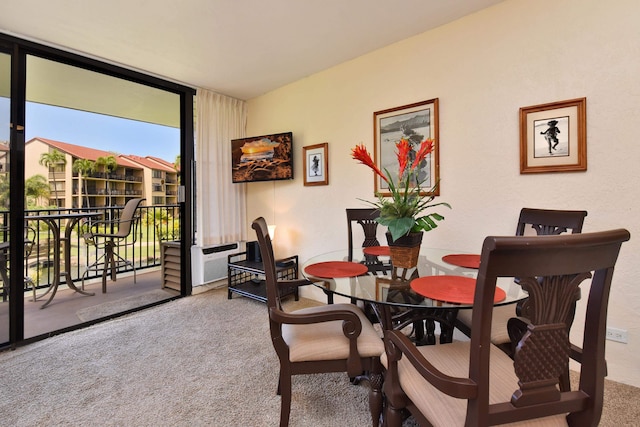 carpeted dining space featuring floor to ceiling windows