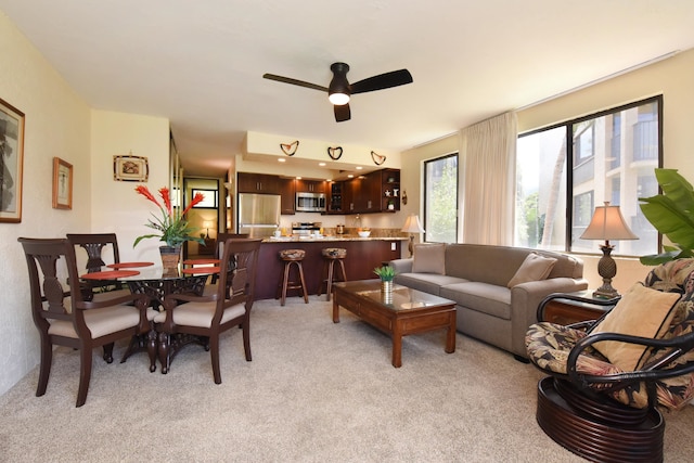 carpeted living room with ceiling fan