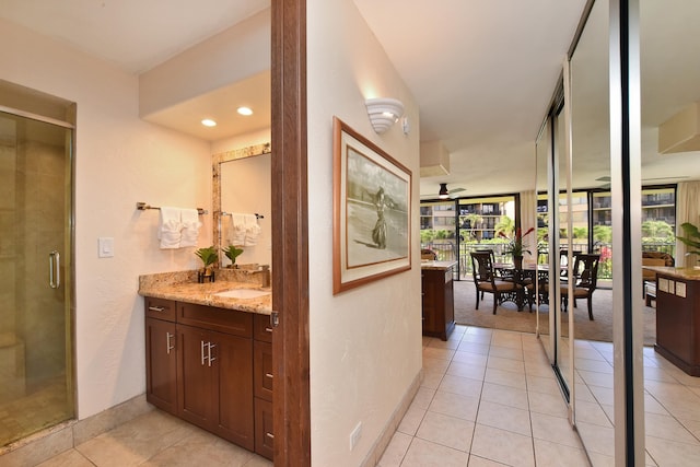 hallway with sink, a healthy amount of sunlight, and light tile floors