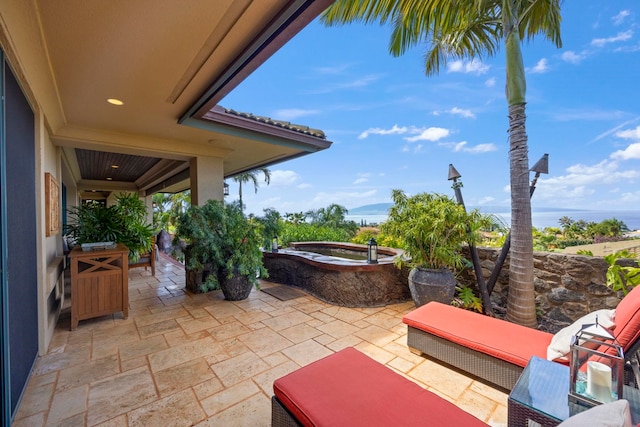 view of terrace featuring a jacuzzi and a water view