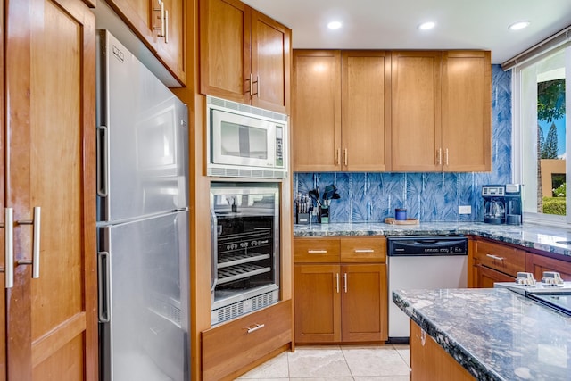 3200 Wailea Alanui Dr Unit 2105, Kihei, HI 96753 - kitchen with stainless steel appliances, beverage cooler, dark stone counters, light tile patterned floors, and brown cabinets