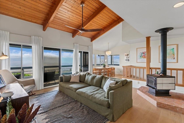 living room with wood ceiling, a wood stove, a water view, and light hardwood / wood-style flooring