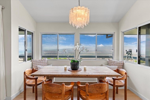 dining area with a wealth of natural light, a chandelier, and light wood-type flooring