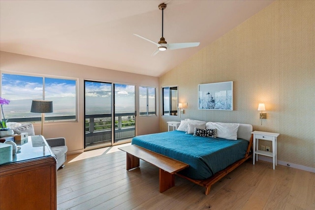 bedroom with ceiling fan, access to exterior, light hardwood / wood-style flooring, and vaulted ceiling