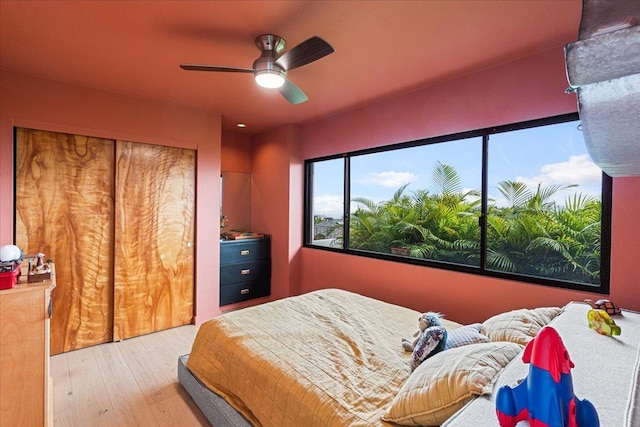 bedroom with ceiling fan, a closet, and light wood-type flooring