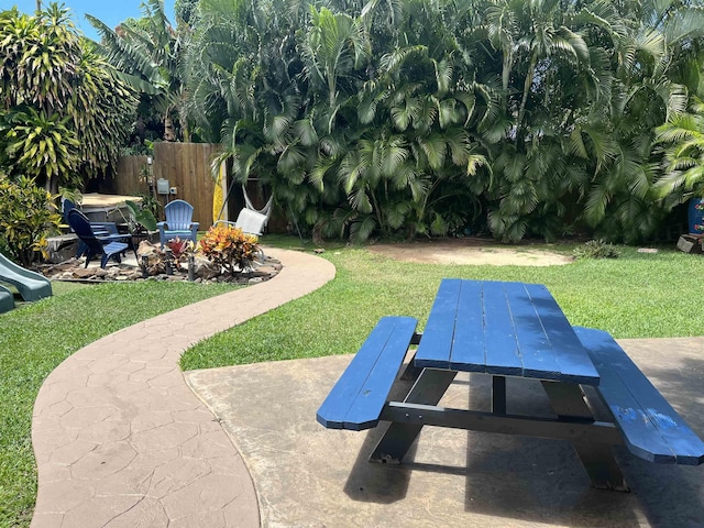 view of yard with an outdoor fire pit, fence, and a patio